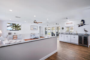 8766 Southeast Longview Drive Hobe Sound, FL 33455 - Photo 10 of 27 a large kitchen with granite countertop a sink and dishwasher a stove with wooden floors