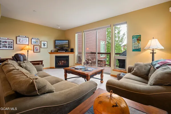 a living room with furniture a large window and a fireplace