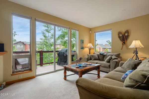 a living room with furniture and a floor to ceiling window