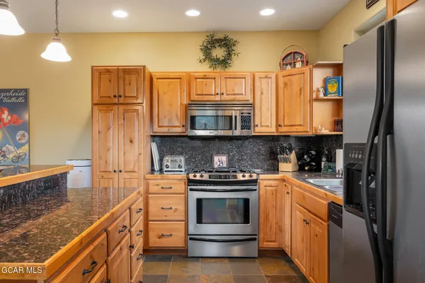 a kitchen with stainless steel appliances granite countertop a stove and a refrigerator