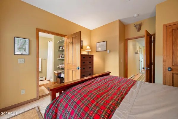 a bedroom with a bed and a dresser with mirror