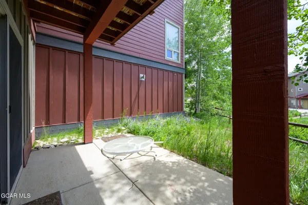 a view of backyard with potted plants and a bench