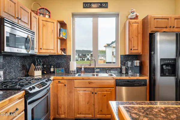 a kitchen with stainless steel appliances granite countertop a stove a sink and a microwave