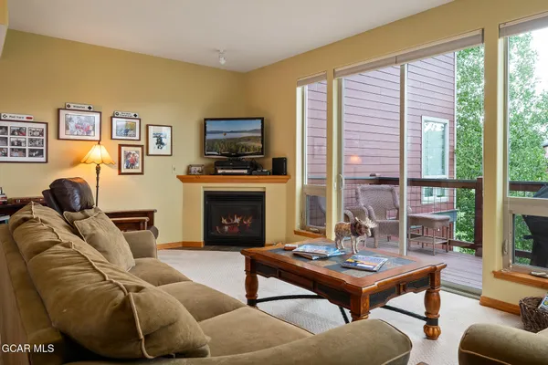a living room with furniture a flat screen tv and a fireplace