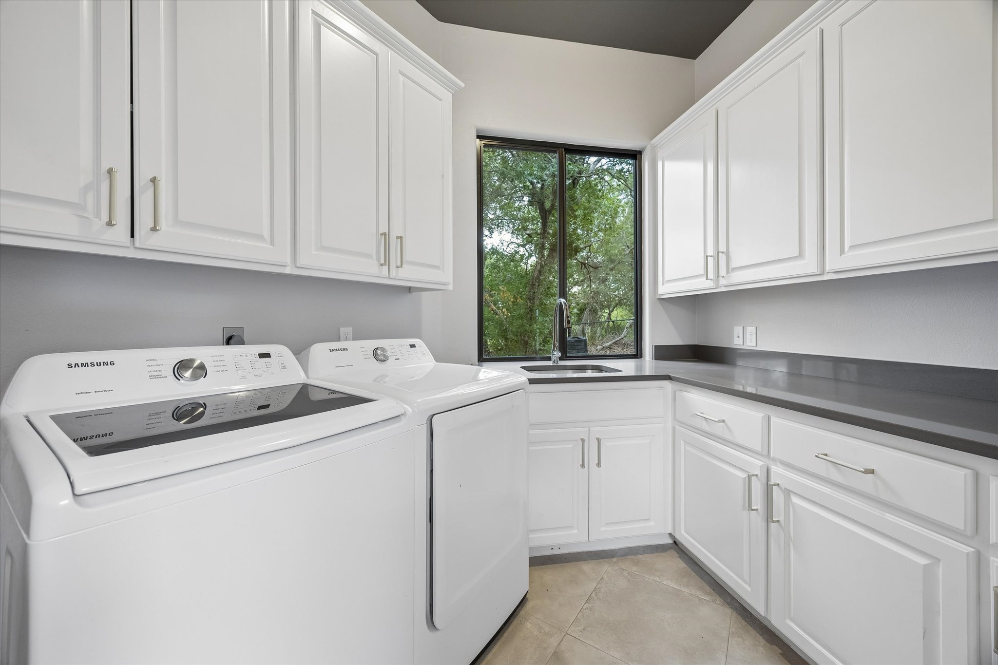 3719 Bee Creek Road Spicewood, TX 78669 - Photo 27 of 40 Ample storage and a view of the outdoors define this well-appointed laundry space.