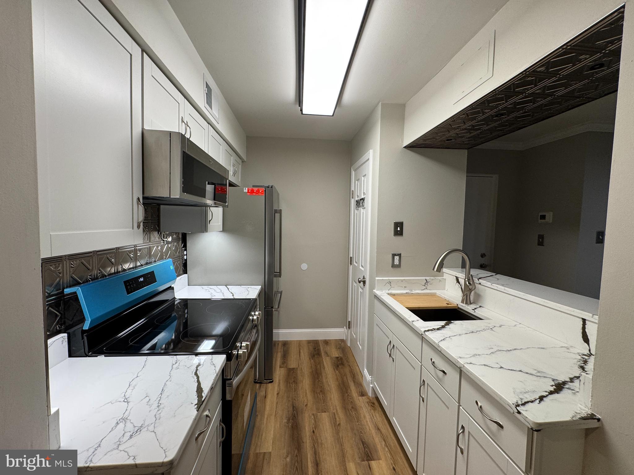 5812 Royal Ridge Drive, Unit C Springfield, VA 22152 - Photo 2 of 21 a kitchen with a sink stove and cabinets