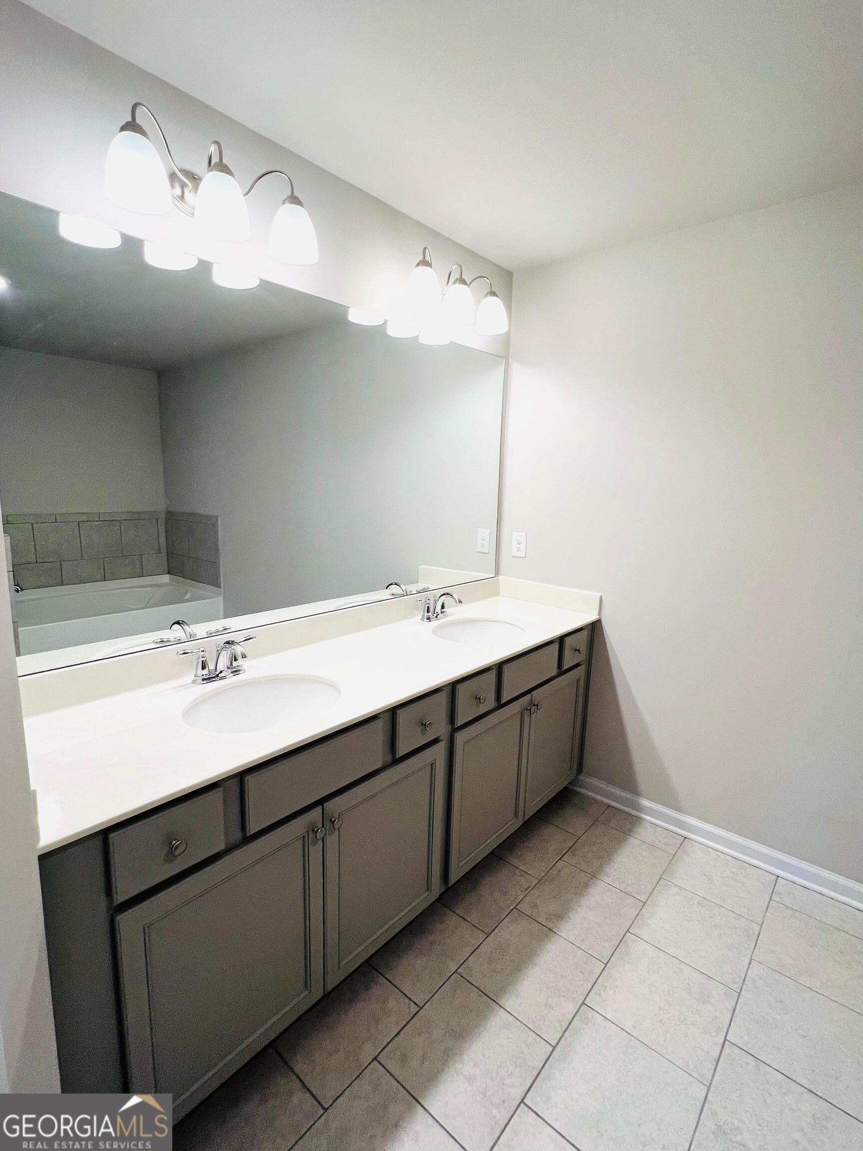 2206 Justify Lane Lithonia, GA 30058 - Photo 15 of 25 a bathroom with a double vanity sink a mirror and vanity