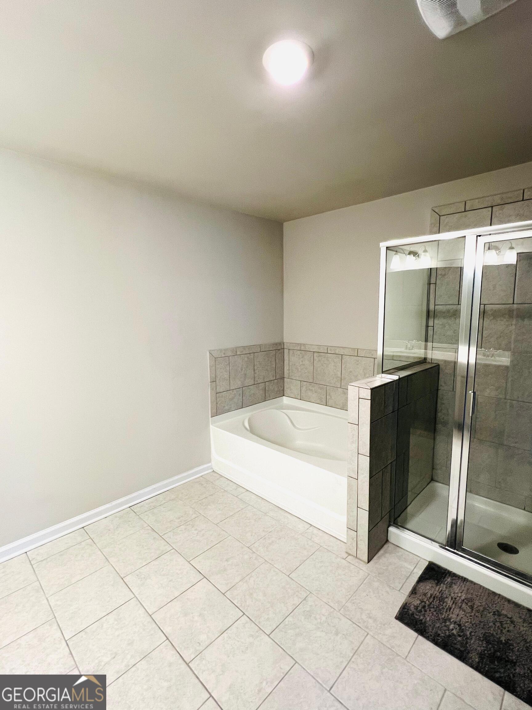 2206 Justify Lane Lithonia, GA 30058 - Photo 16 of 25 a bathroom with a bathtub and shower