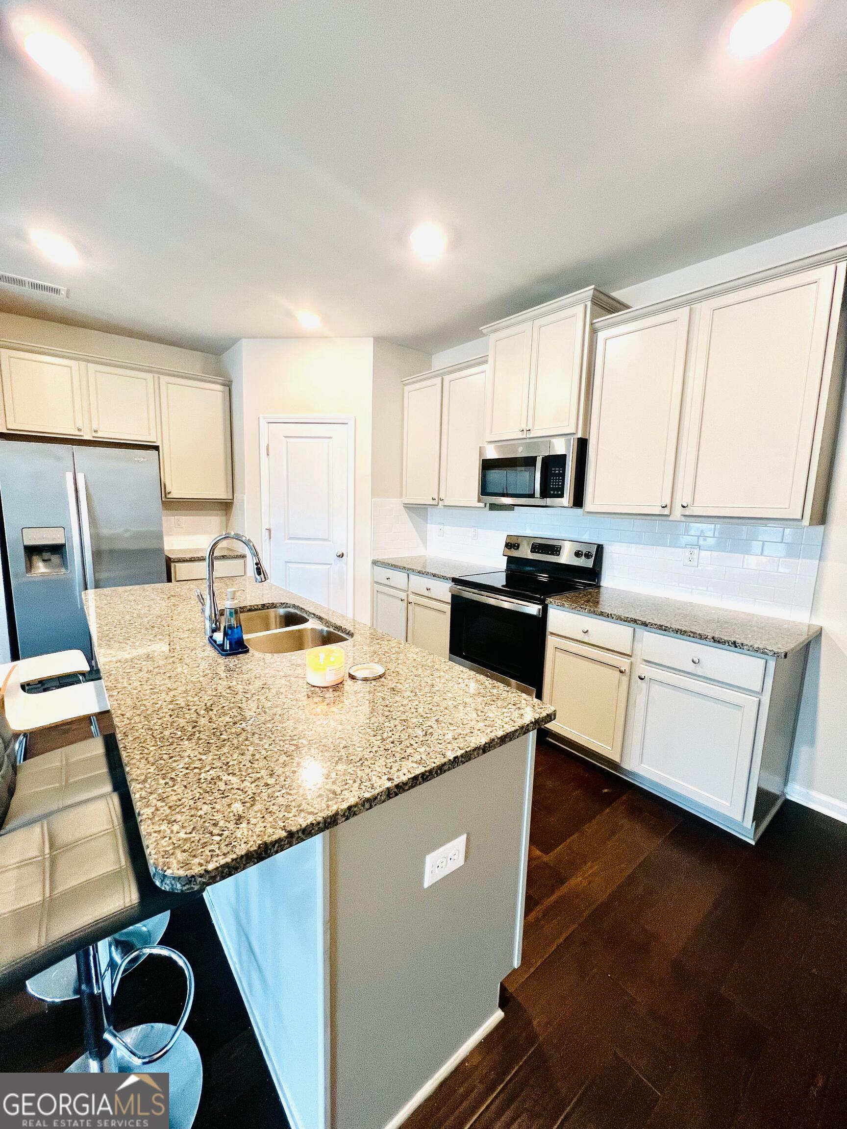 2206 Justify Lane Lithonia, GA 30058 - Photo 5 of 25 a kitchen with stainless steel appliances granite countertop a sink stove refrigerator and microwave