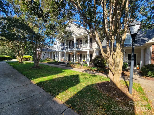 a view of a yard in front of a brick house with plants