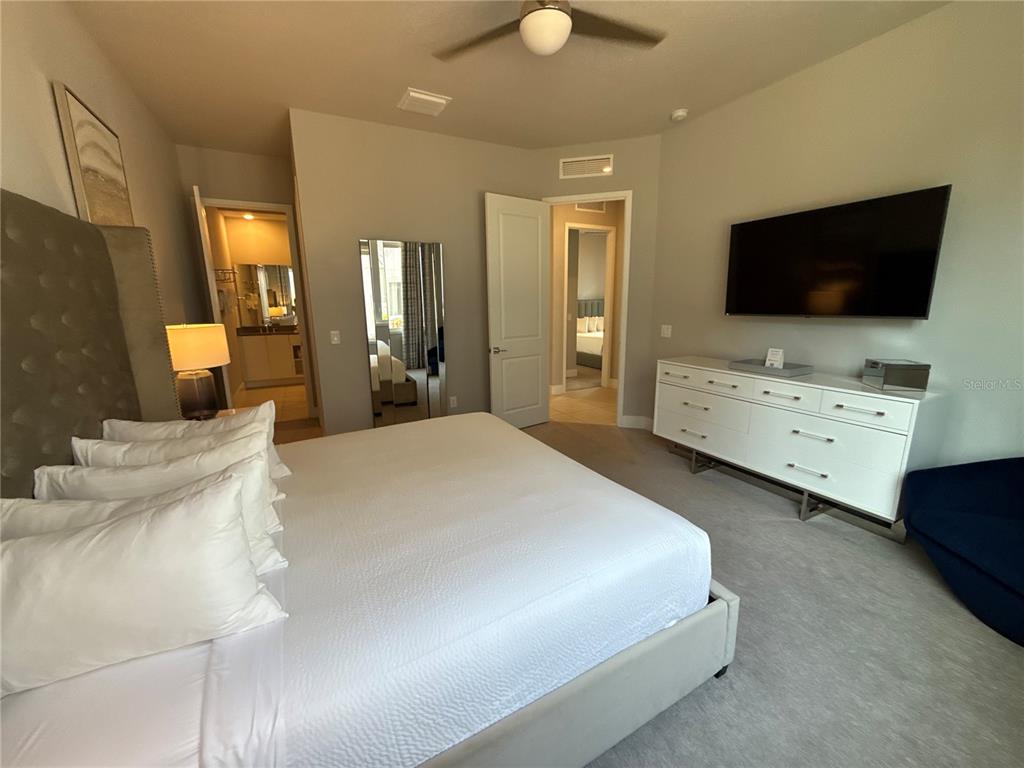 7740 Sandy Ridge Drive, Unit 120 Reunion, FL 34747 - Photo 15 of 36 a bedroom with a bed and a flat screen tv