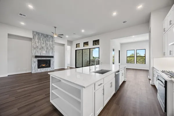 a large white kitchen with sink and refrigerator