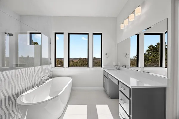 a spacious bathroom with a tub sink and mirror