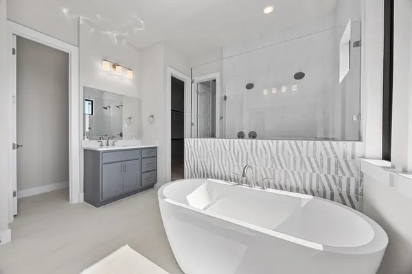 a bathroom with a bathtub a sink a window and a mirror