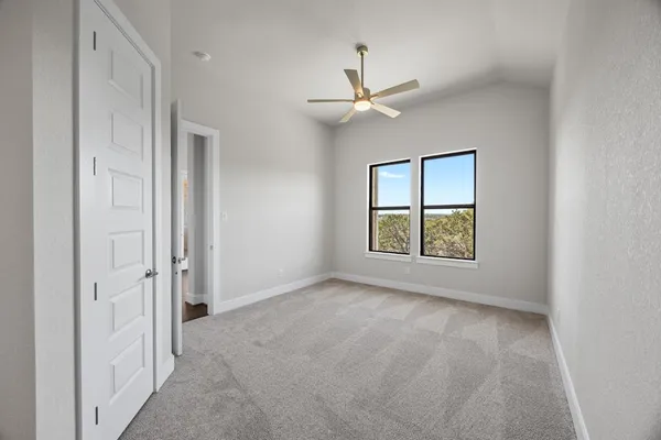 an empty room with windows and fan