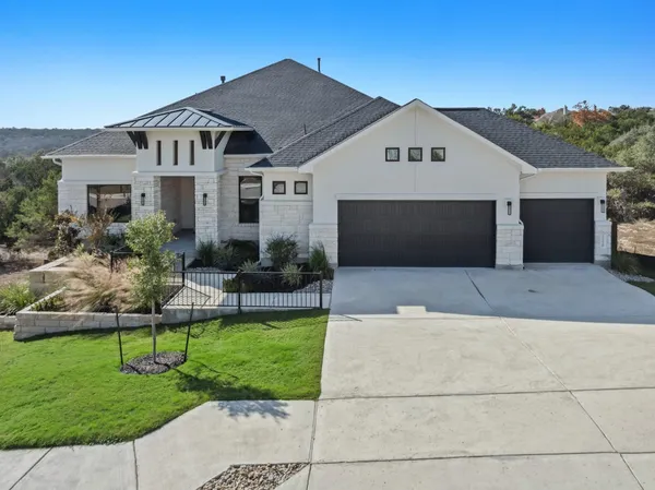 a front view of a house with a yard and potted plants