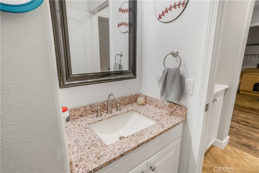 35814 Anderson Street Beaumont, CA 92223 - Photo 19 of 75 a bathroom with a granite countertop sink and a mirror