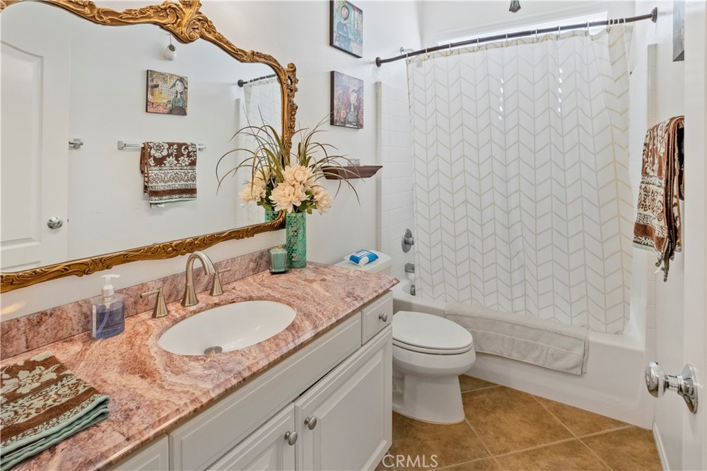 35814 Anderson Street Beaumont, CA 92223 - Photo 37 of 75 a bathroom with a granite countertop sink a toilet and a mirror