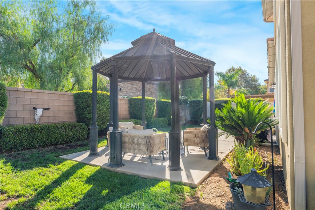35814 Anderson Street Beaumont, CA 92223 - Photo 56 of 75 a backyard of a house with table and chairs under an umbrella