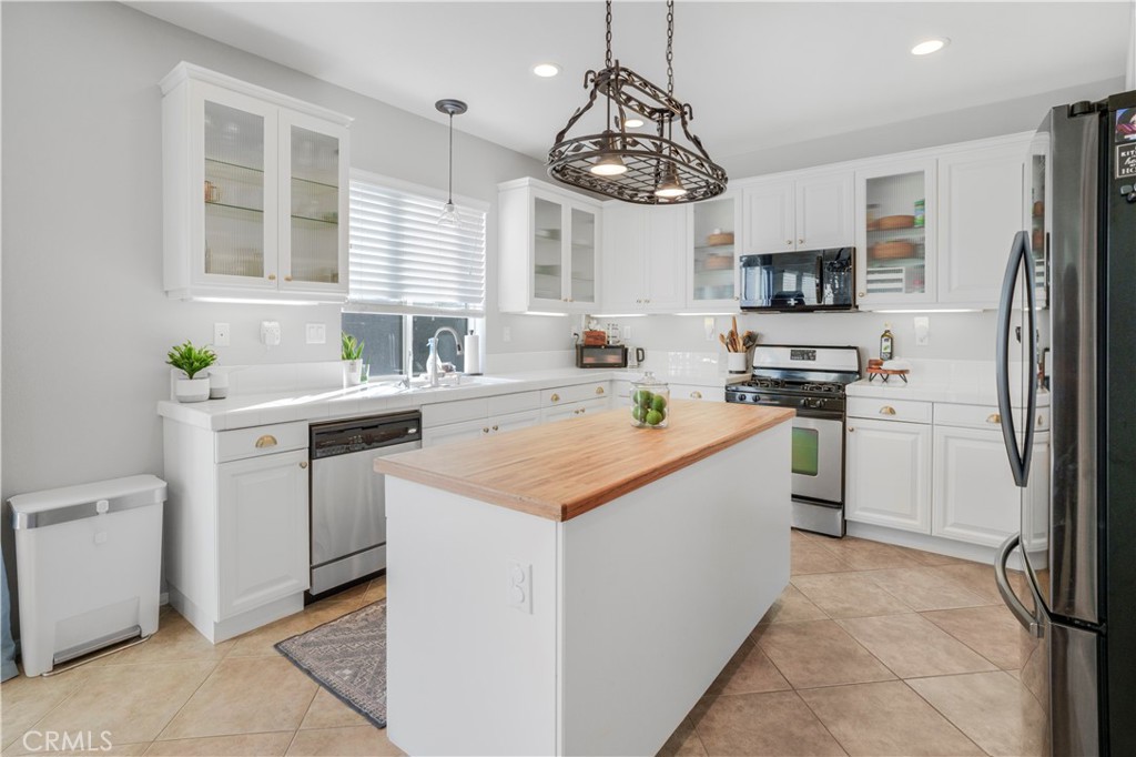 35814 Anderson Street Beaumont, CA 92223 - Photo 6 of 75 a kitchen with a sink dishwasher a stove a refrigerator and a dining table with wooden floor