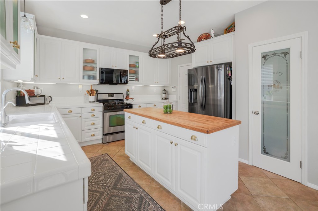 35814 Anderson Street Beaumont, CA 92223 - Photo 7 of 75 a kitchen that has a lot of white cabinets and stainless steel appliances