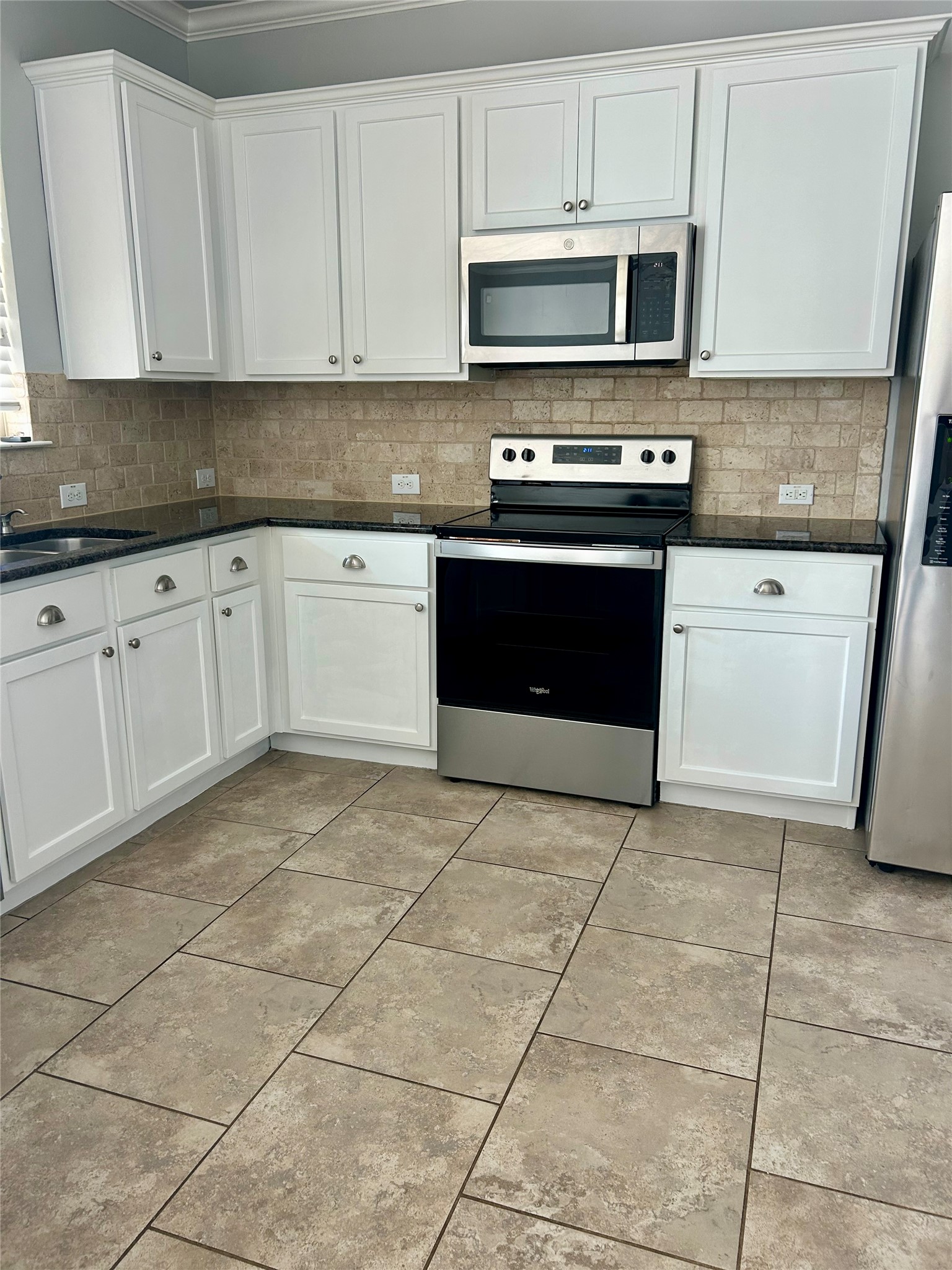 117 Chickadee Lane Leander, TX 78641 - Photo 2 of 24 a kitchen with stainless steel appliances granite countertop a stove a sink and a microwave