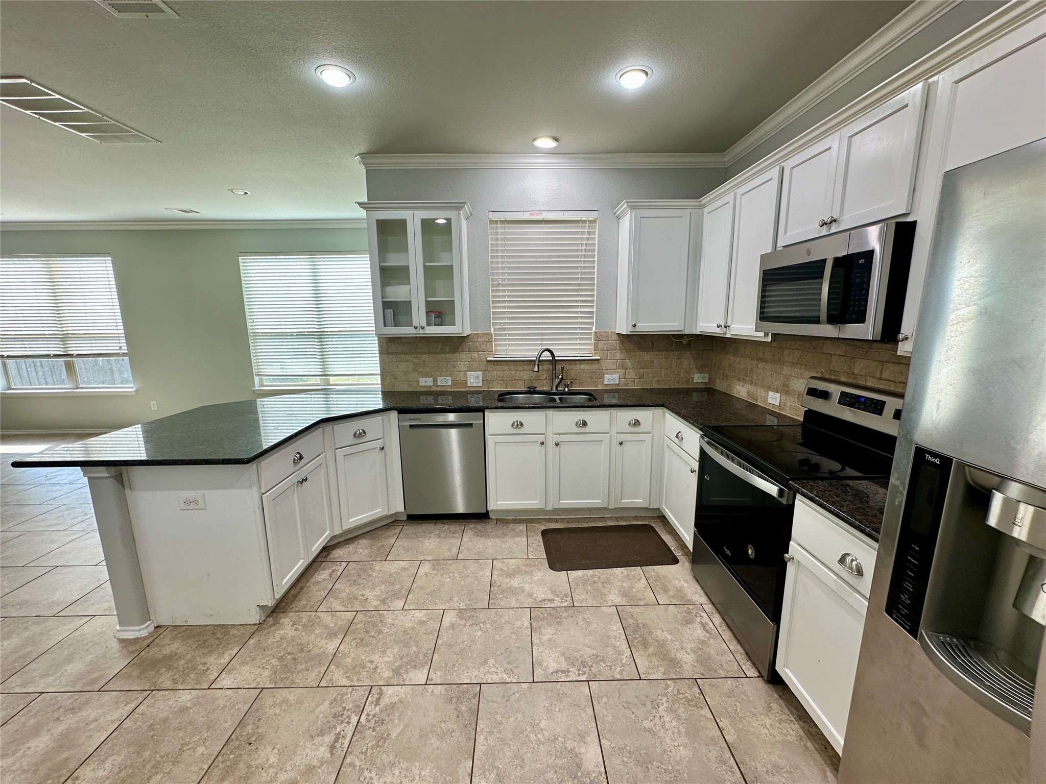 117 Chickadee Lane Leander, TX 78641 - Photo 5 of 24 a kitchen with stainless steel appliances granite countertop a sink a stove top oven and white cabinets