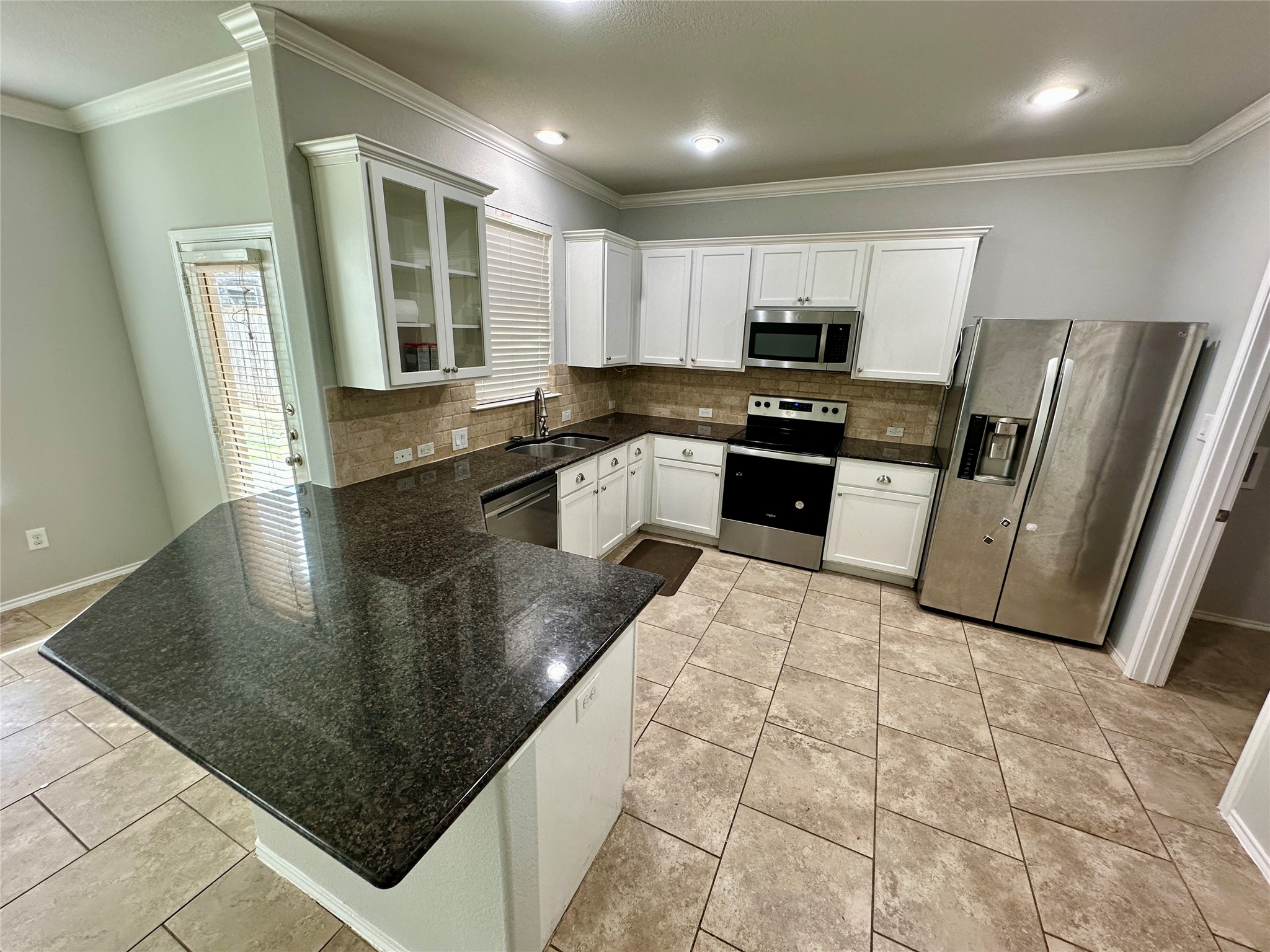 117 Chickadee Lane Leander, TX 78641 - Photo 6 of 24 a large kitchen with stainless steel appliances granite countertop a sink refrigerator and microwave