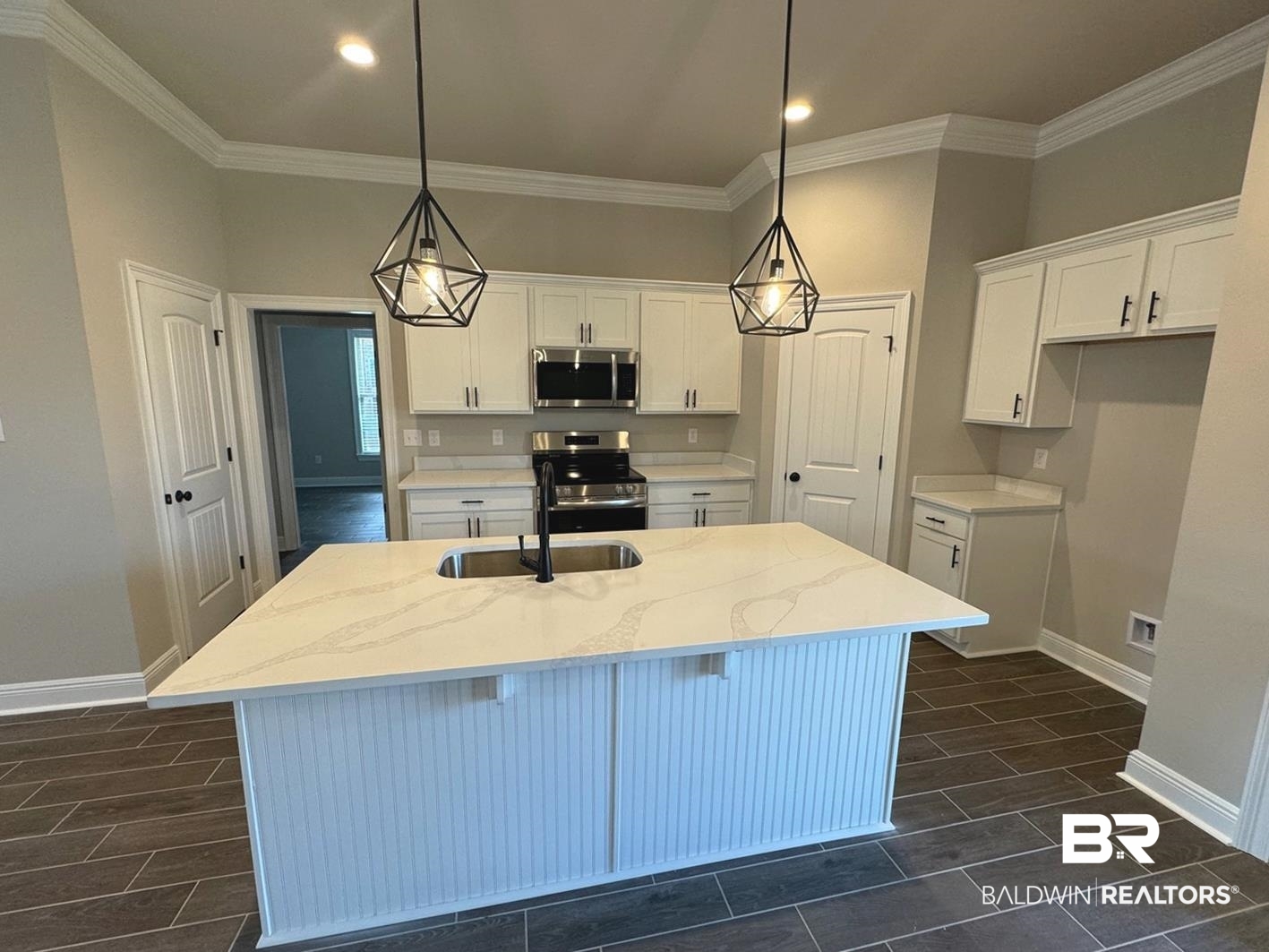 888 Sumter Loop Foley, AL 36535 - Photo 2 of 8 Kitchen with white cabinetry, stainless steel appliances, light stone countertops, and a kitchen island with sink