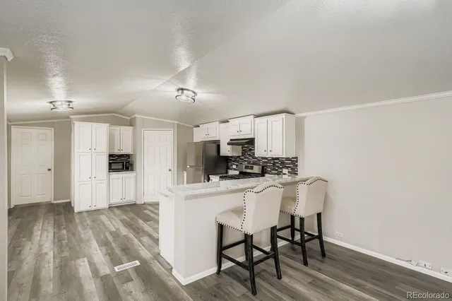 a kitchen with white cabinets and stainless steel appliances