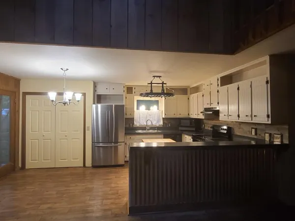 a kitchen with granite countertop a refrigerator and a sink