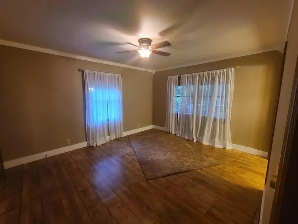 a view of an empty room with wooden floor