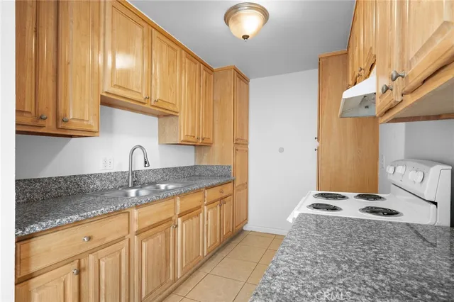 a kitchen with granite countertop cabinets stainless steel appliances and a counter space