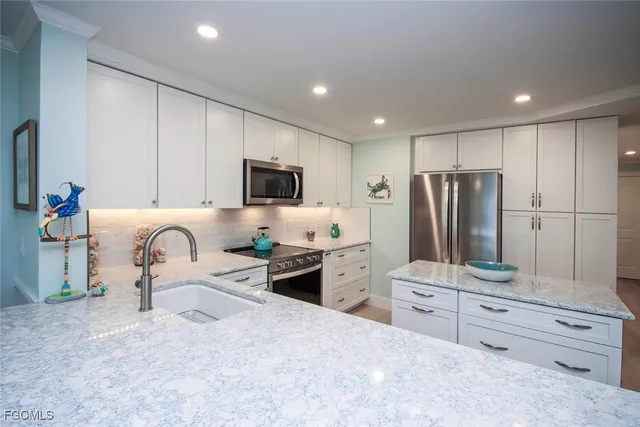 a kitchen with granite countertop a refrigerator and a stove top oven