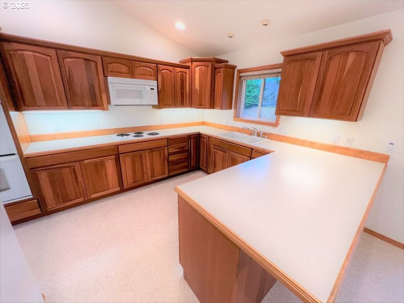 92831 Walluski Loop Astoria, OR 97103 - Photo 22 of 32 a kitchen with stainless steel appliances a refrigerator a sink and a stove top oven