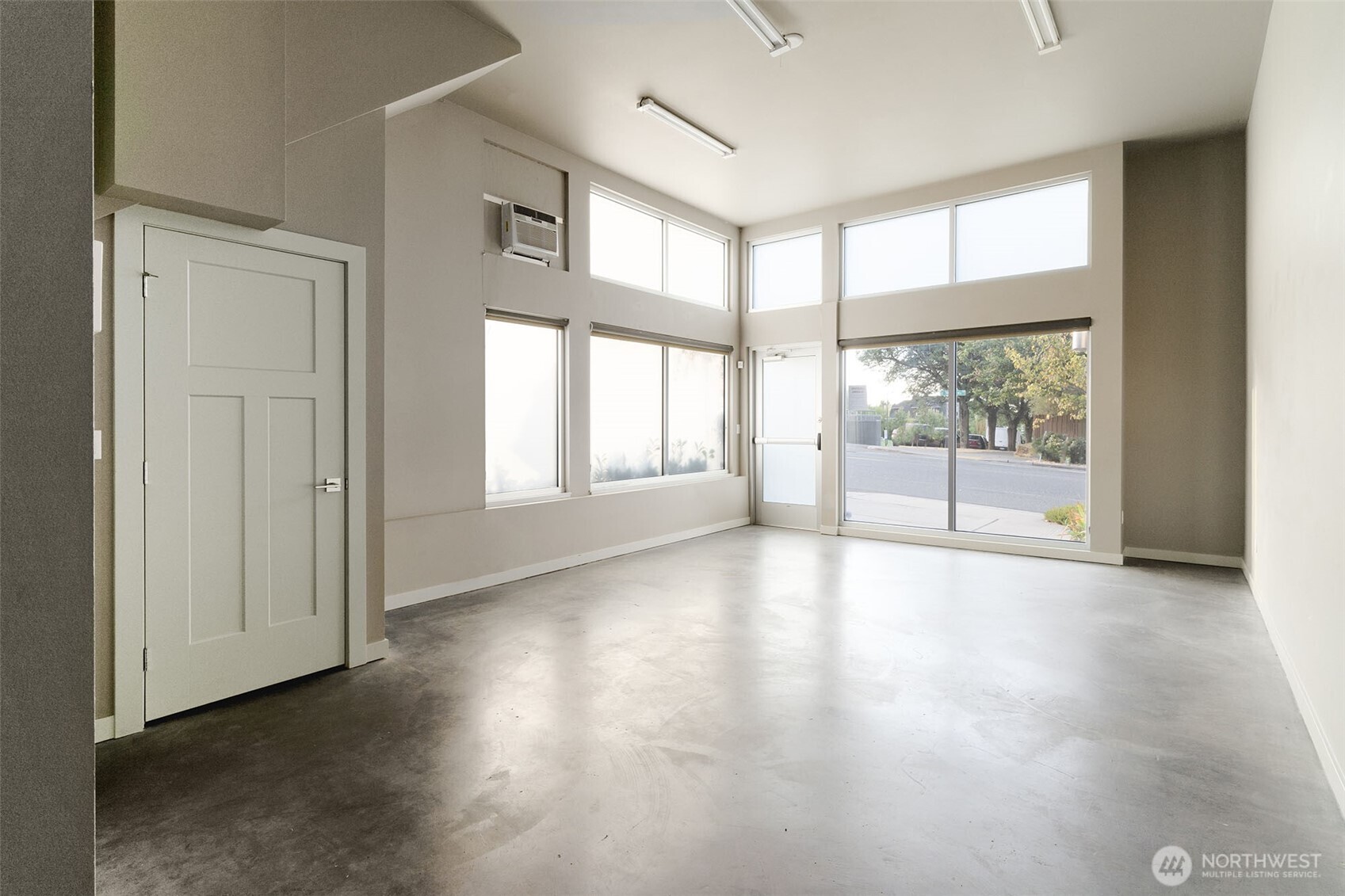 1626 East Yesler Way Seattle, WA 98122 - Photo 2 of 12 a view of an empty room with wooden floor and a window