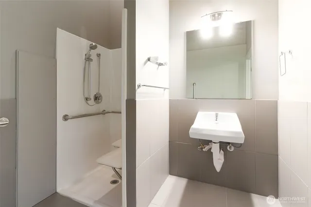 a bathroom with a shower a sink and mirror