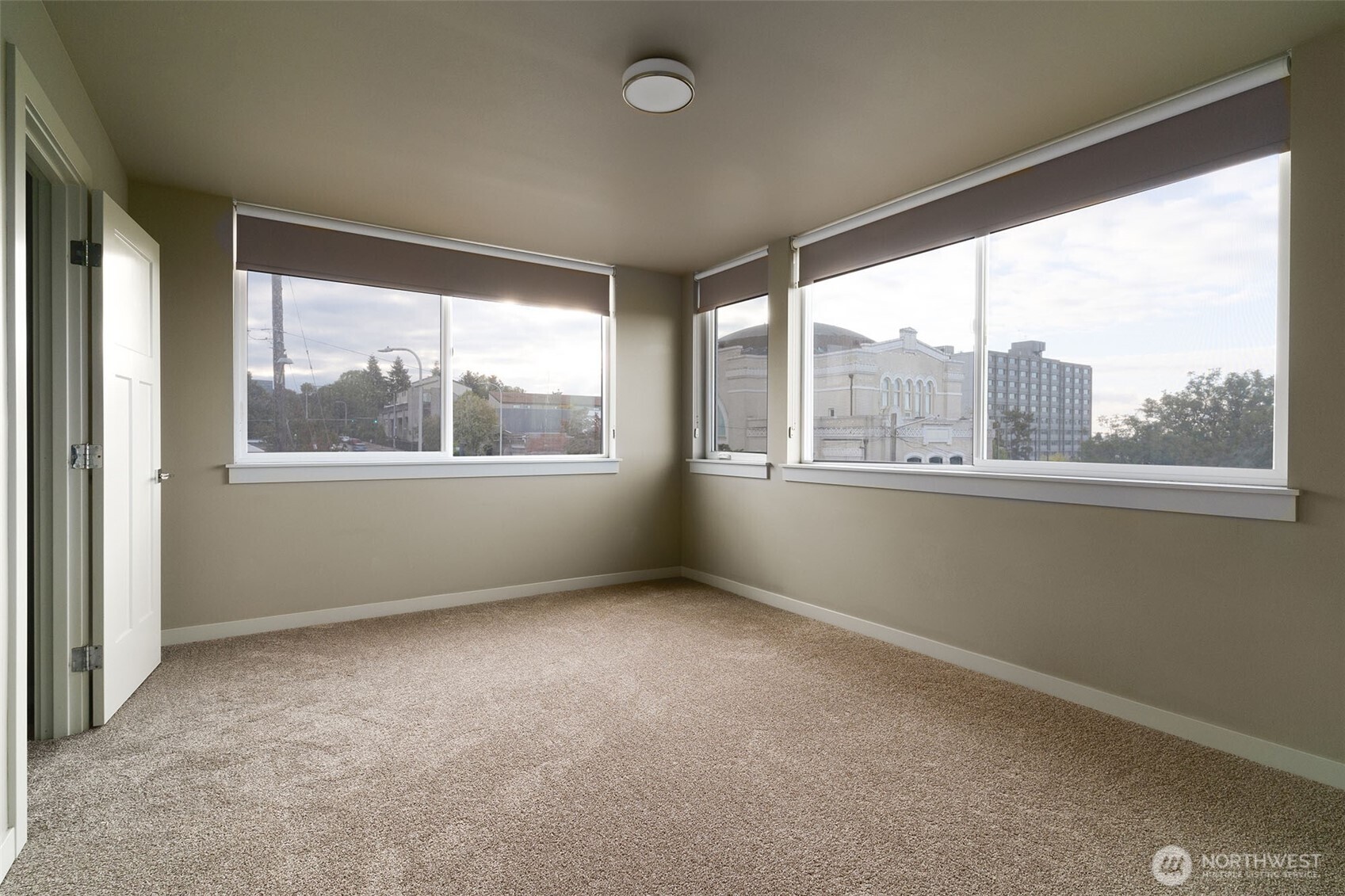 1626 East Yesler Way Seattle, WA 98122 - Photo 7 of 12 an empty room with wooden floor and windows
