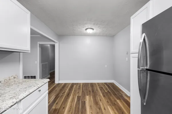 a view of an empty room with a fireplace and a window
