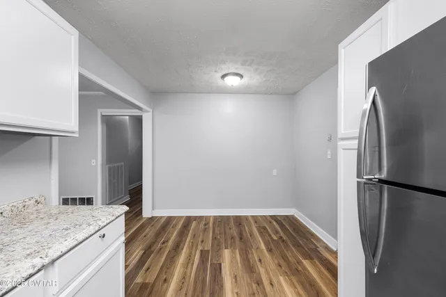 a view of an empty room with a fireplace and a window