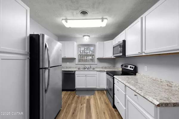 a kitchen with a sink a stove and cabinets