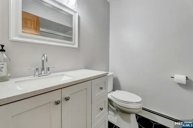 a bathroom with a toilet a sink and mirror