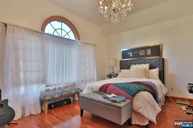 a bedroom with a bed and a chandelier