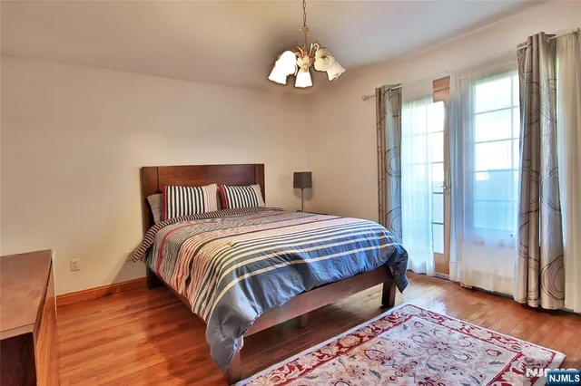 a bedroom with a large bed and a chandelier