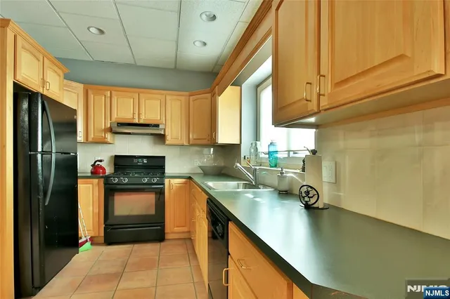 a kitchen with stainless steel appliances a sink a stove and a refrigerator
