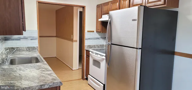a metallic refrigerator freezer sitting in a kitchen