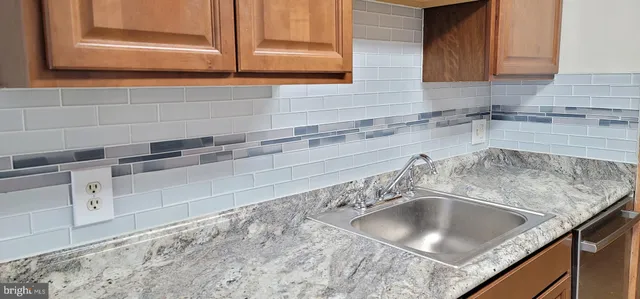 a kitchen with granite countertop a sink a stove and cabinets