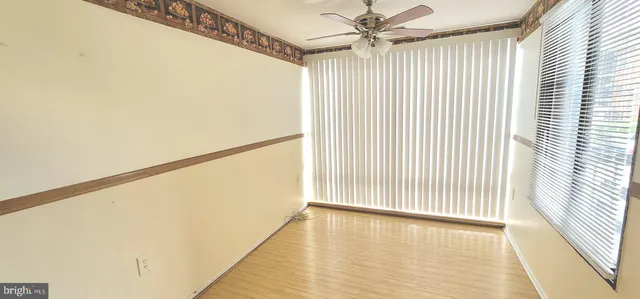 a view of a big room with wooden floor and windows