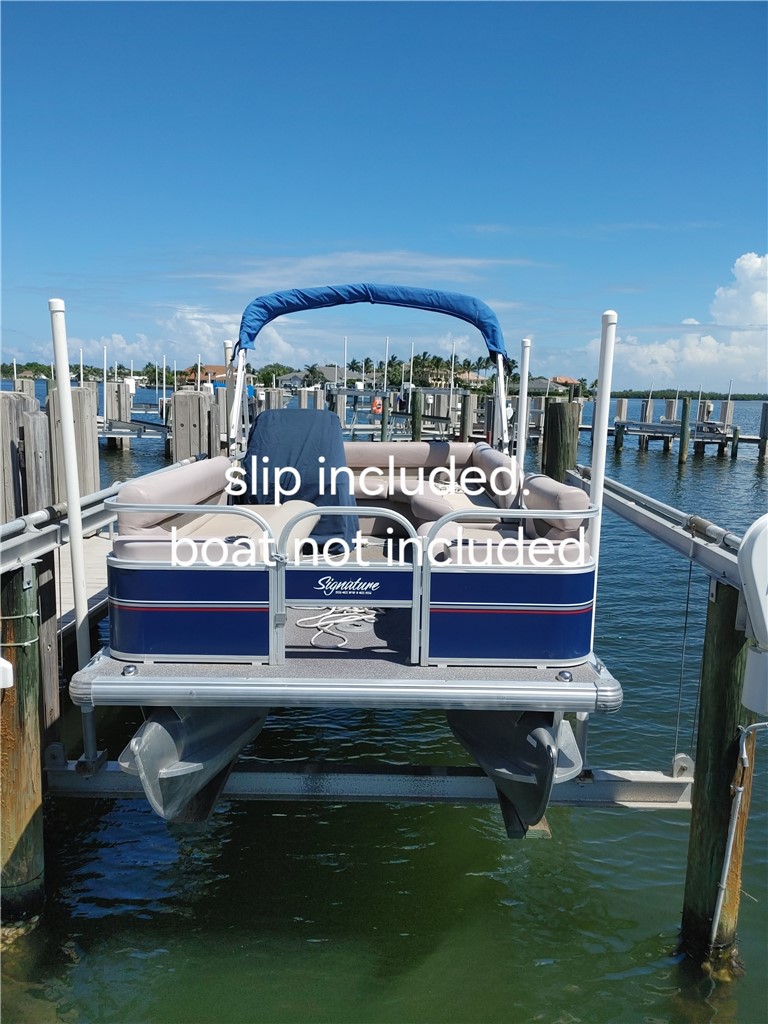 1903 Bay Road, Unit 206 Vero Beach, FL 32963 - Photo 18 of 30 a view of a patio with table and chairs a barbeque with wooden fence