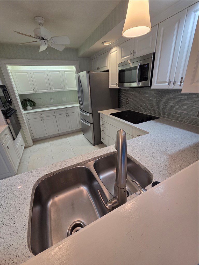 1903 Bay Road, Unit 206 Vero Beach, FL 32963 - Photo 21 of 30 a kitchen with a sink and a microwave